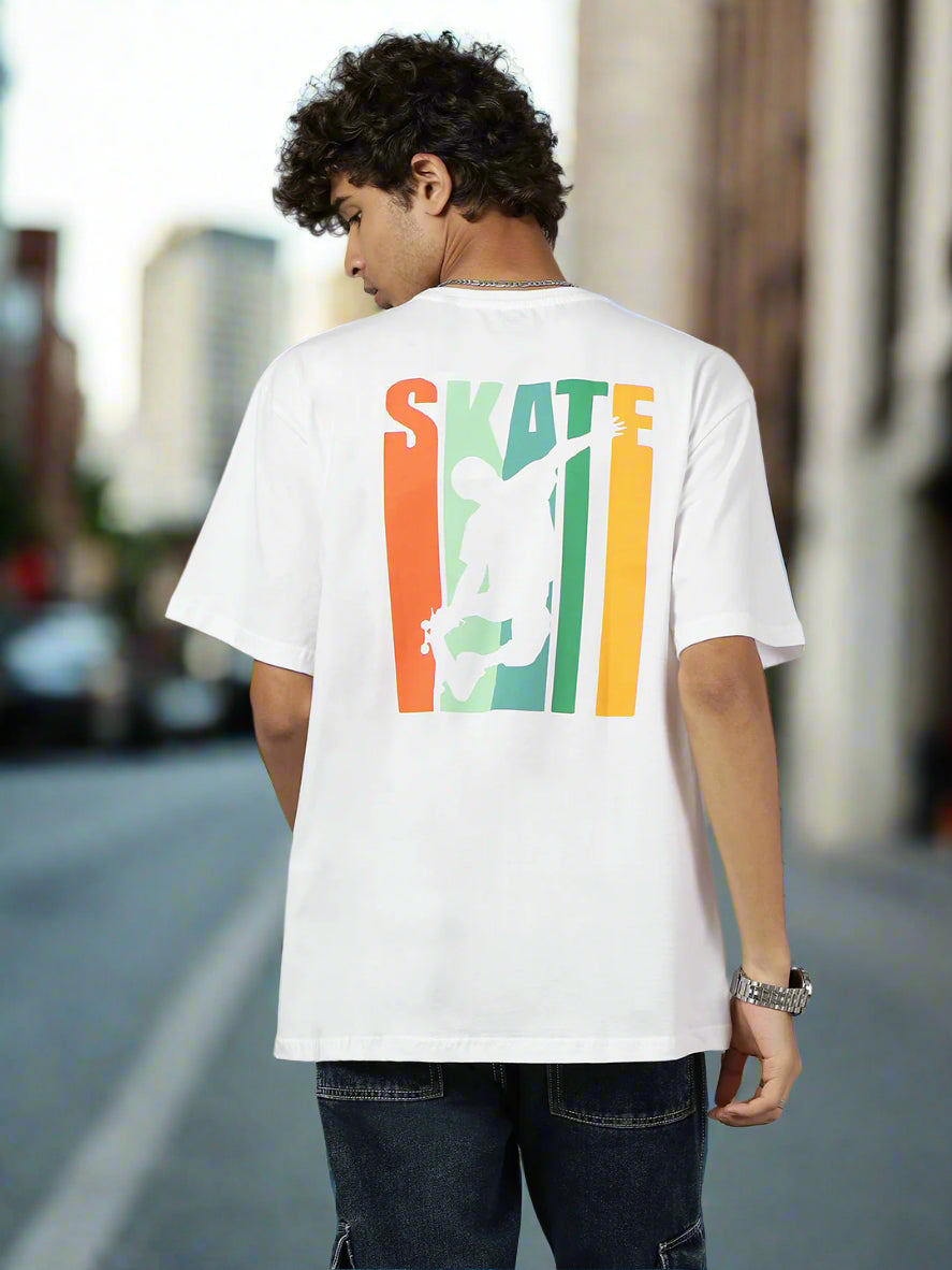 Person wearing a white t-shirt with a colorful 'SKATE' graphic on the back against a gray background